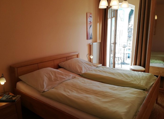 Schlafzimmer mit Doppelbett und Zugang zum Balkon