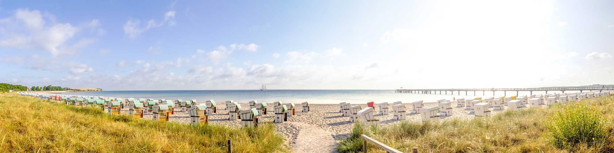 Panorama Bild mit Blick auf den Strand mit Strandkörben und die Ostsee