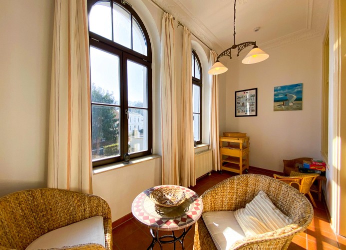 verglaste Veranda mit Korbbestuhlung