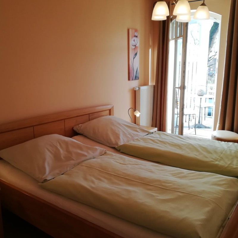 Schlafzimmer mit Doppelbett und Zugang zum Balkon